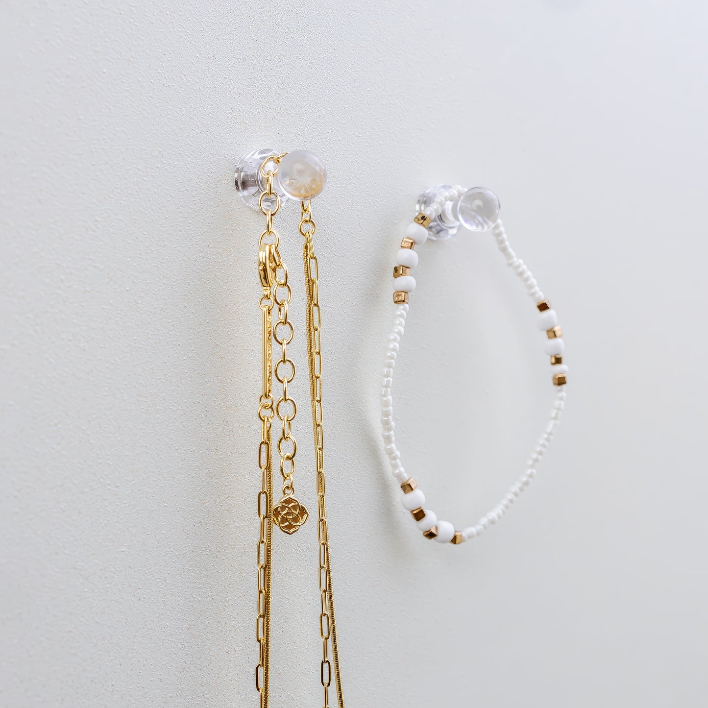 Clear mini magnets that hold jewelry on a shimmer pearl metal board that is a magnetic board for holding jewelry and doubles as a memo board