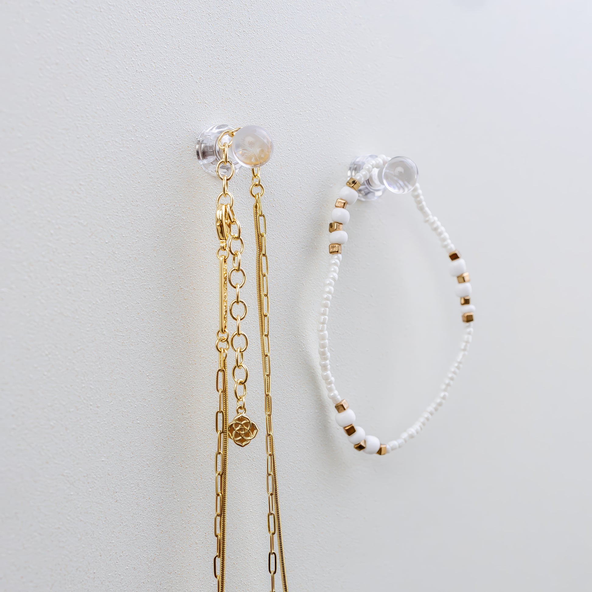 Clear mini magnets that hold jewelry on a shimmer pearl metal board that is a magnetic board for holding jewelry and doubles as a memo board